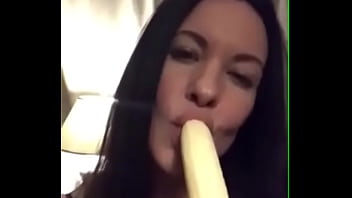 brunette girl  with a banana in mouth